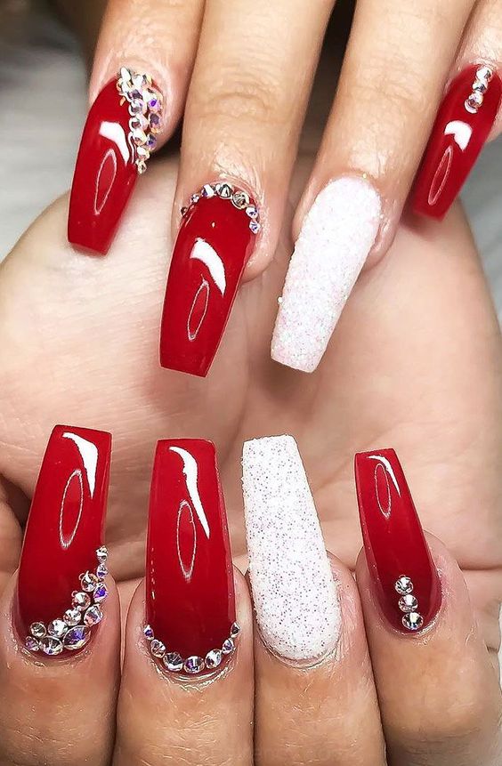 Red glossy nails with rhinestones in a spiral pattern